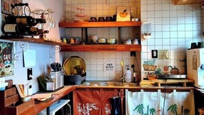 Une cuisine avec des étagères en bois, une machine à café et divers ustensiles de cuisine.
