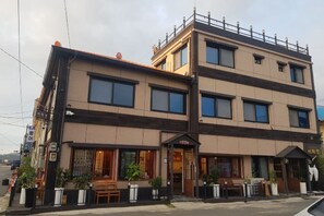 Een gebouw met meerdere verdiepingen, een restaurant op de begane grond en een woongebied op de tweede verdieping.