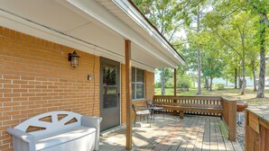 A covered porch with a brick wall, a white bench, and a grill area. - Walk to Greers Ferry Lake! Home w/ Dock Access (Greers Ferry)