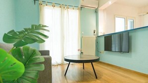 A living room with a round table, a sofa, and a large plant. - Ma de Bright Stay Attiki Metro (Athens)