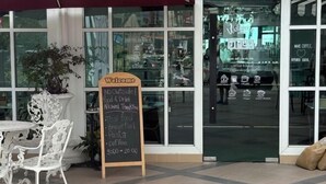 Ein Café mit einer Schiefertafel, die thailändische Speisen, Frühstück und Kaffee anbietet.