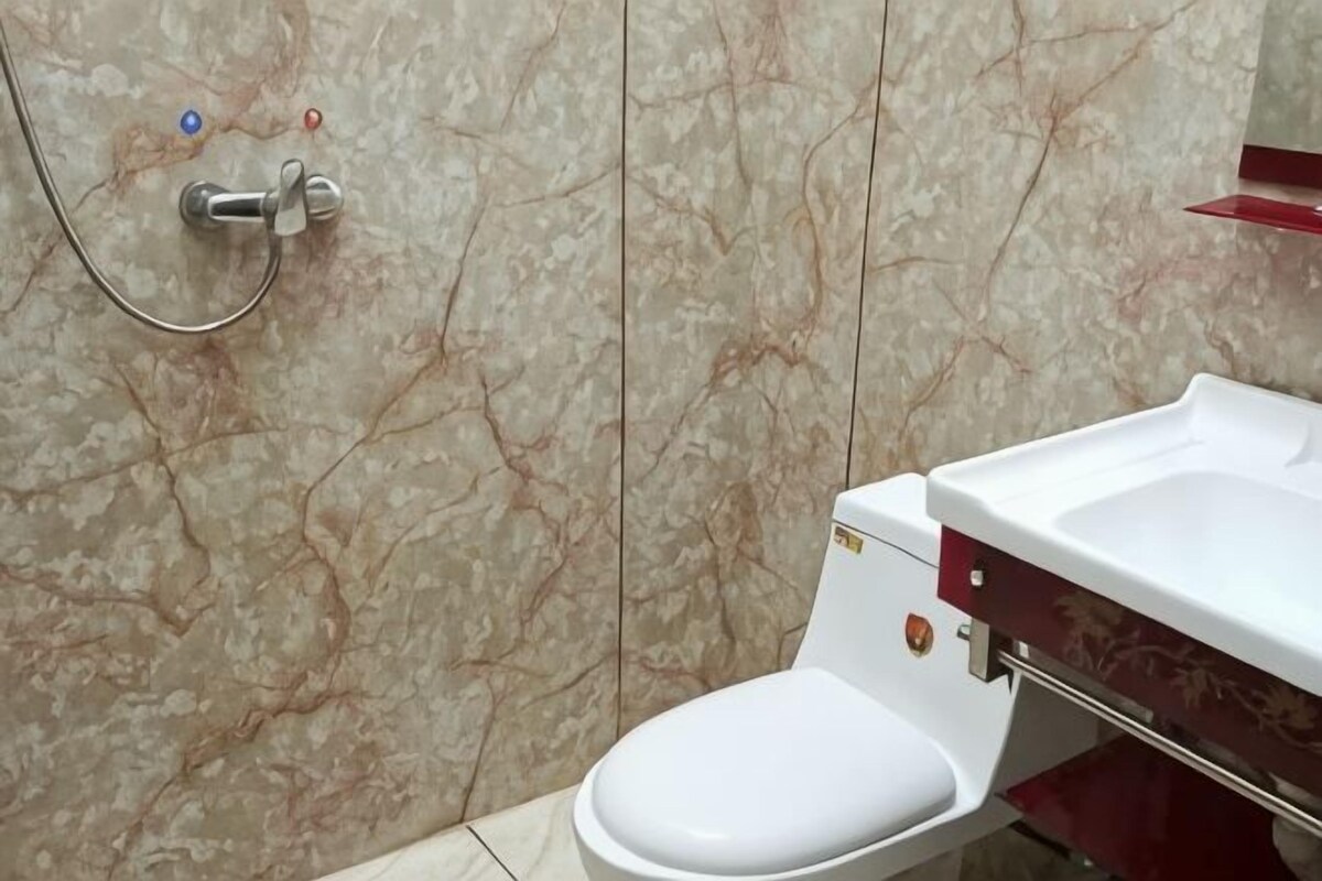 A bathroom with a toilet, a shower, and a sink.