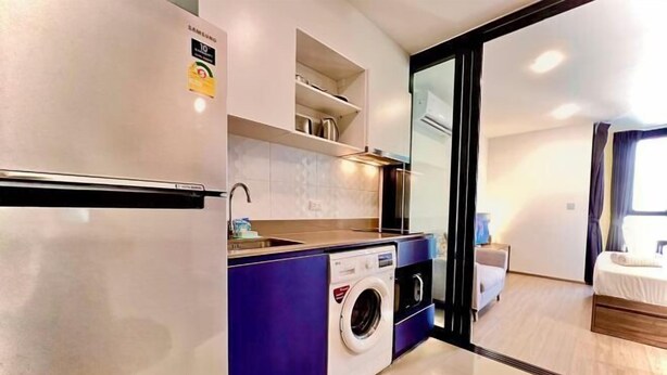 Eine moderne Küche mit Waschmaschine, Kühlschrank und Einbauofen.