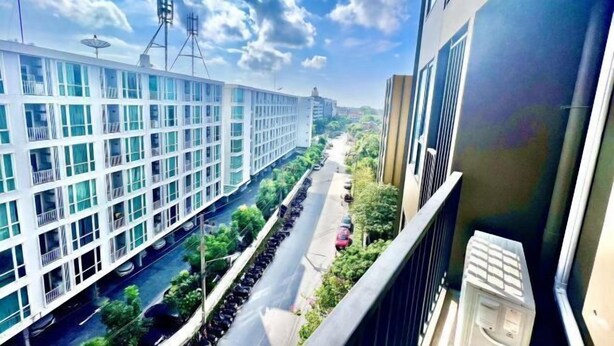 A modern building with a long corridor and a narrow road in front. - The Base Central Condominium (Phuket)