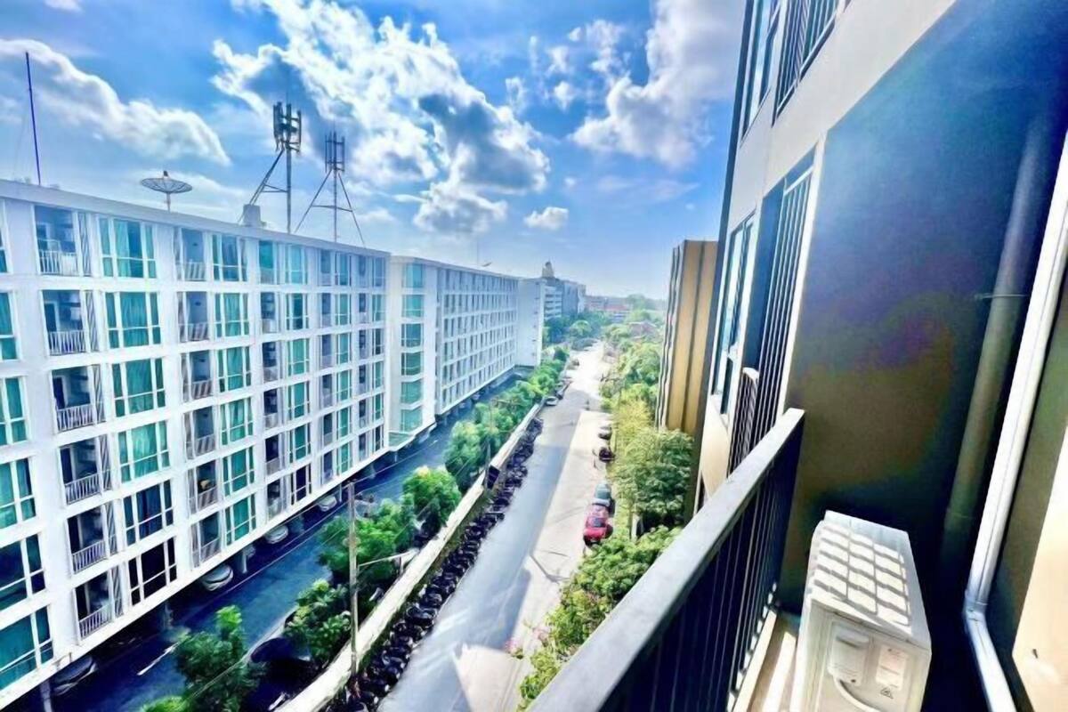 A modern building with a long corridor and a narrow road in front.