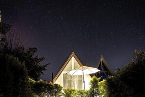 A triangular-shaped building with a large glass window and an umbrella. - Paradise Resort & Cafe (Chiang Dao)