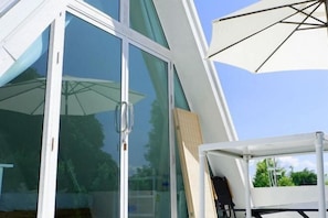 A modern building with large glass doors and a white umbrella. - Paradise Resort & Cafe (Chiang Dao)