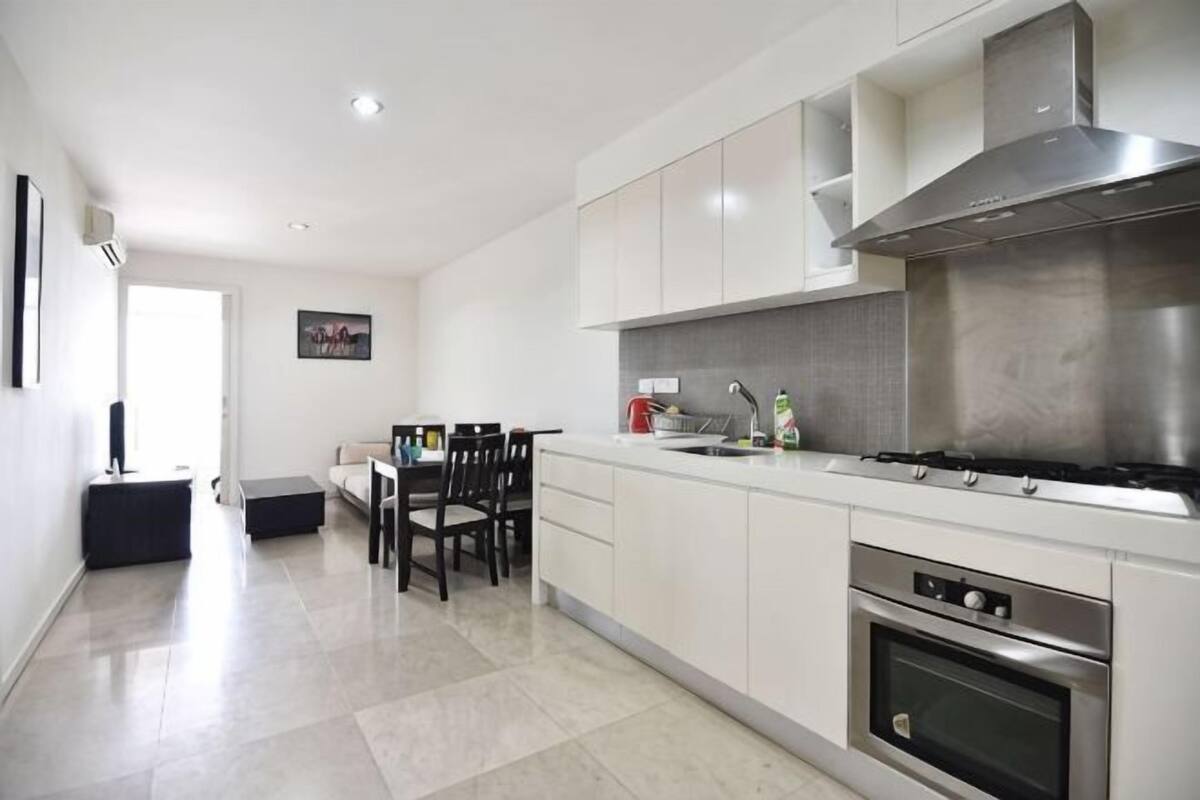 A modern kitchen with white cabinets, a gas stove, and an oven.