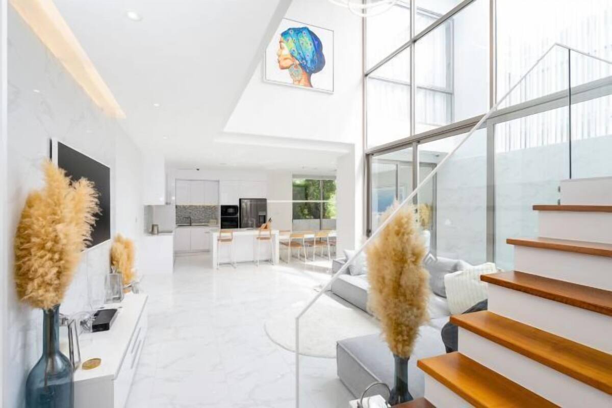Un intérieur moderne comprenant un escalier, une cuisine et un coin repas.