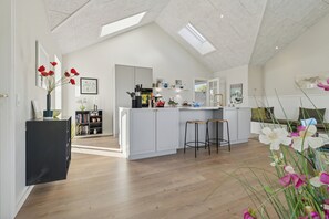 Eine moderne Küche mit Kochinsel, Holzböden und Dachfenstern.