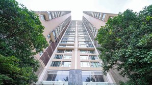 A high-rise building with a central glass atrium and multiple floors. - Tyms Premium 1BR 1BA Apt Yongxin Century (Shanghai)