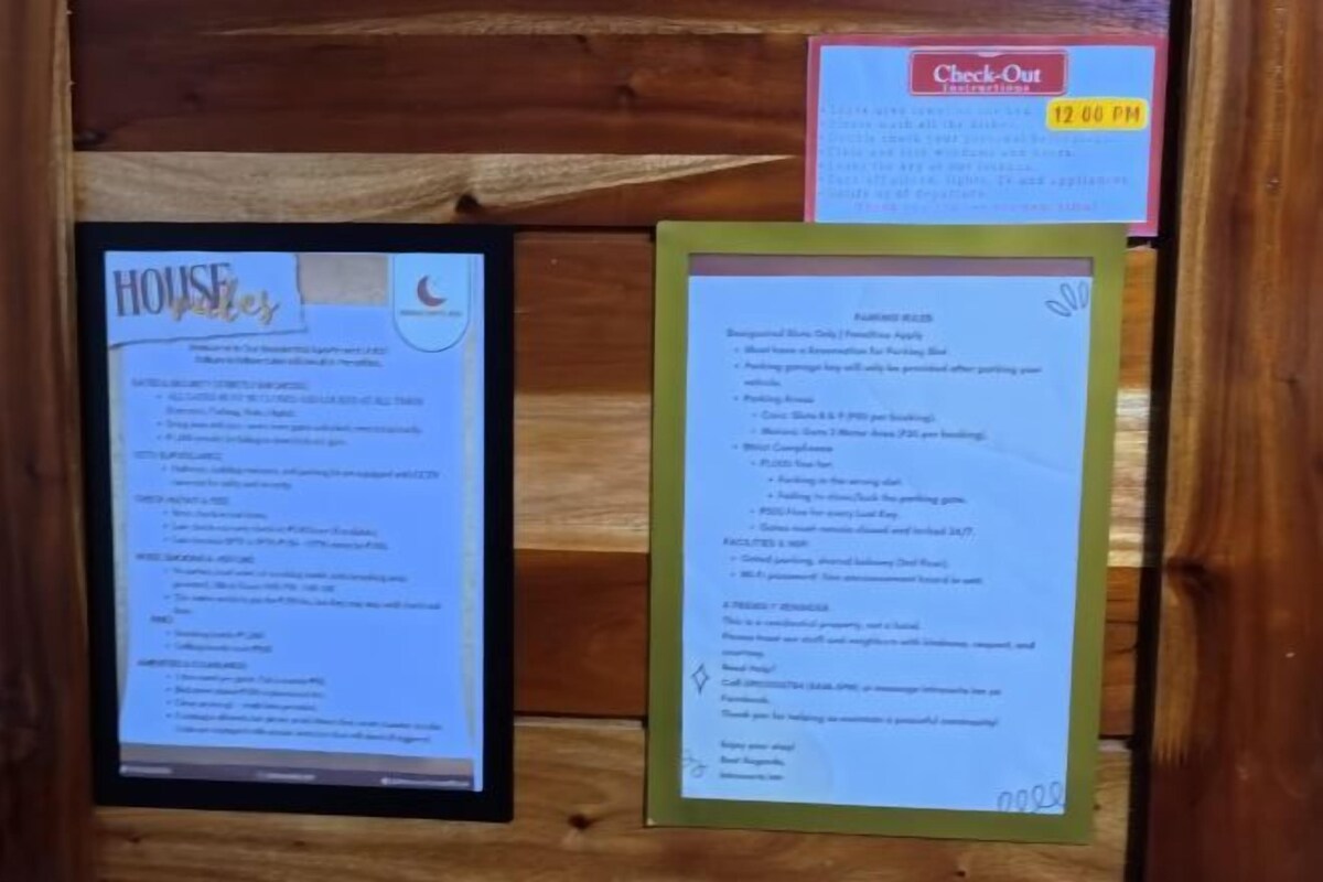 A framed notice board with a 'Check-Out Instructions' sign and a 'House Rules' notice.