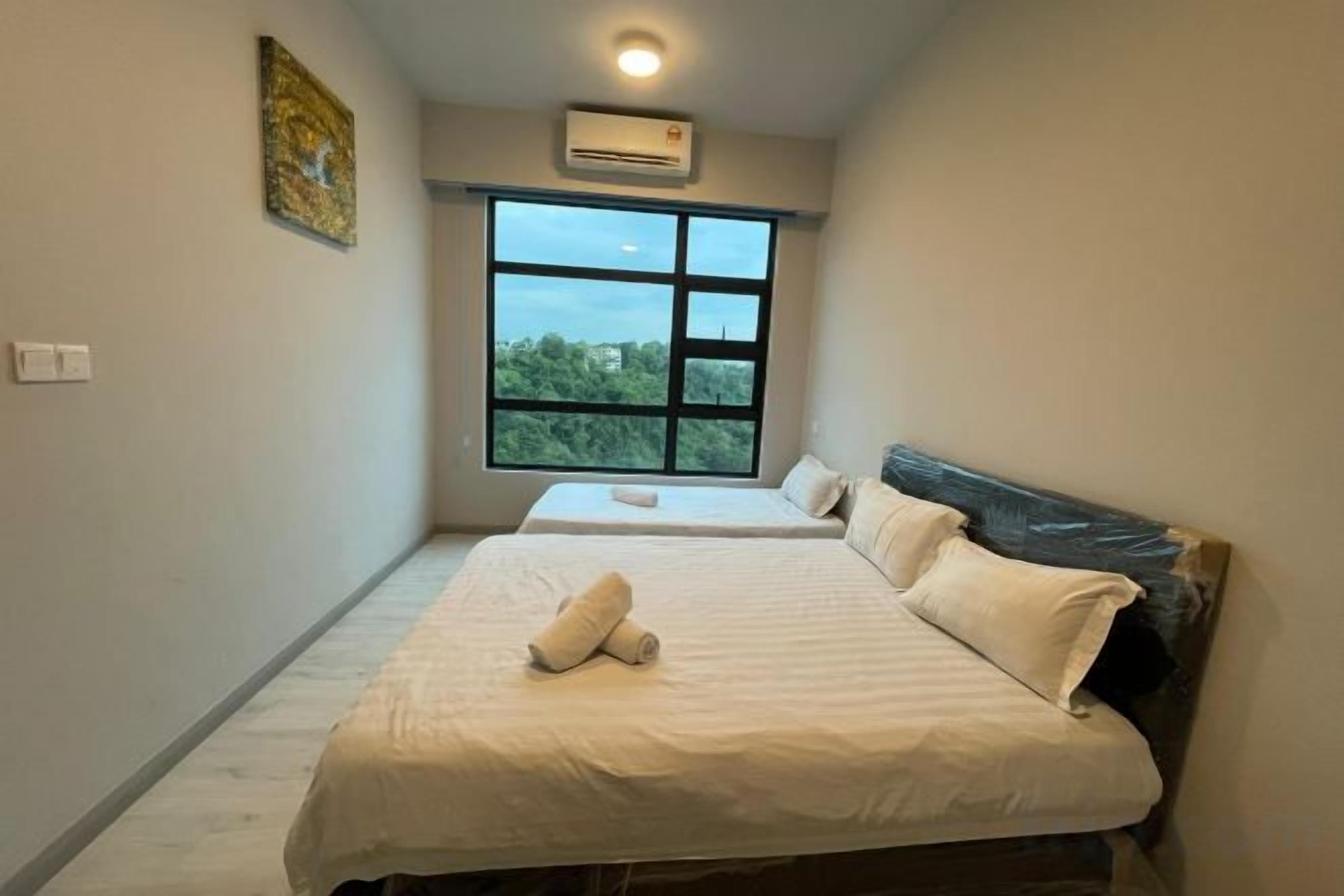 A bedroom with a large window, a bed with white linens, and a ceiling fan.