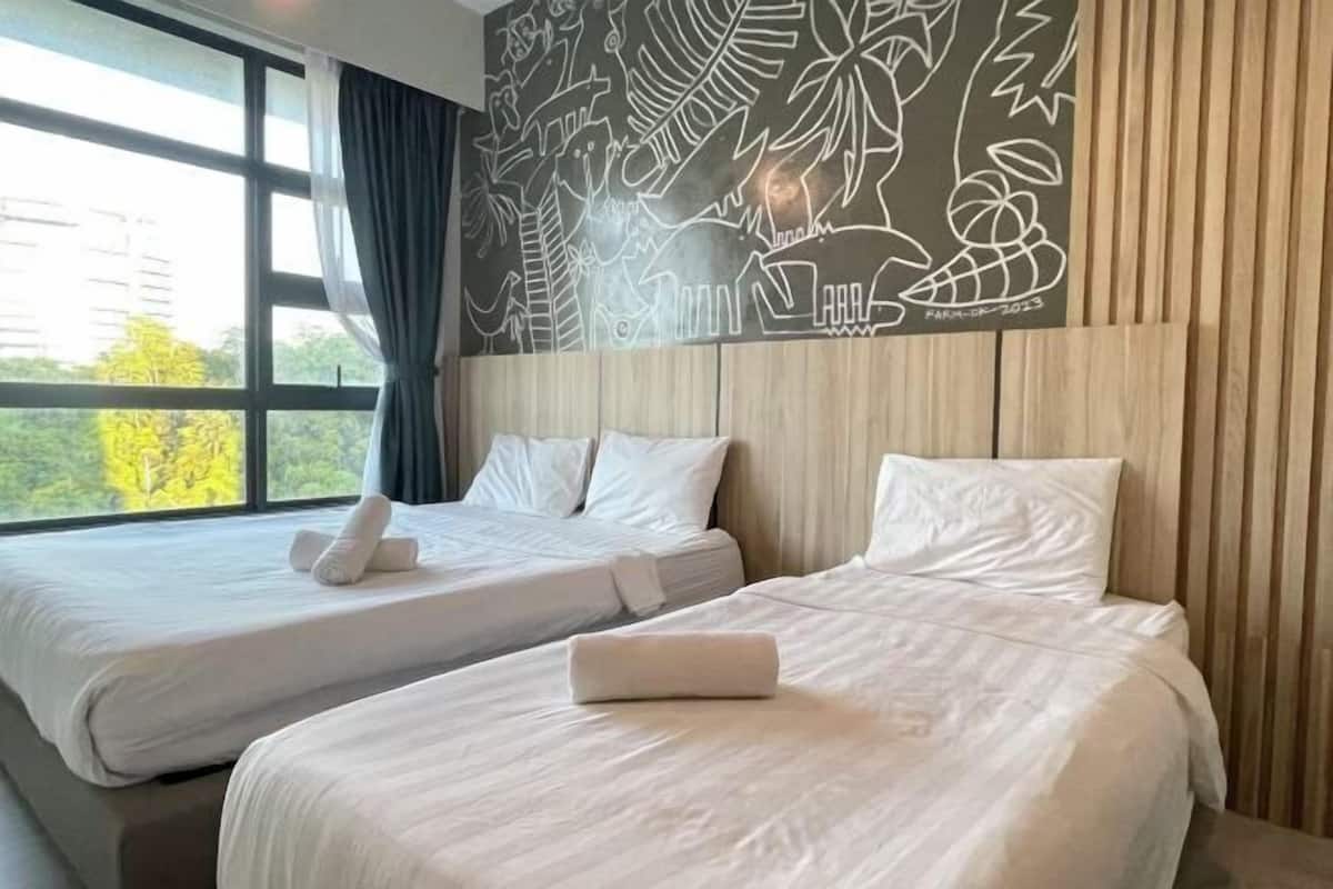 Ein Hotelzimmer mit zwei Betten, einem großen Fenster mit Vorhängen und einem Wandgemälde.