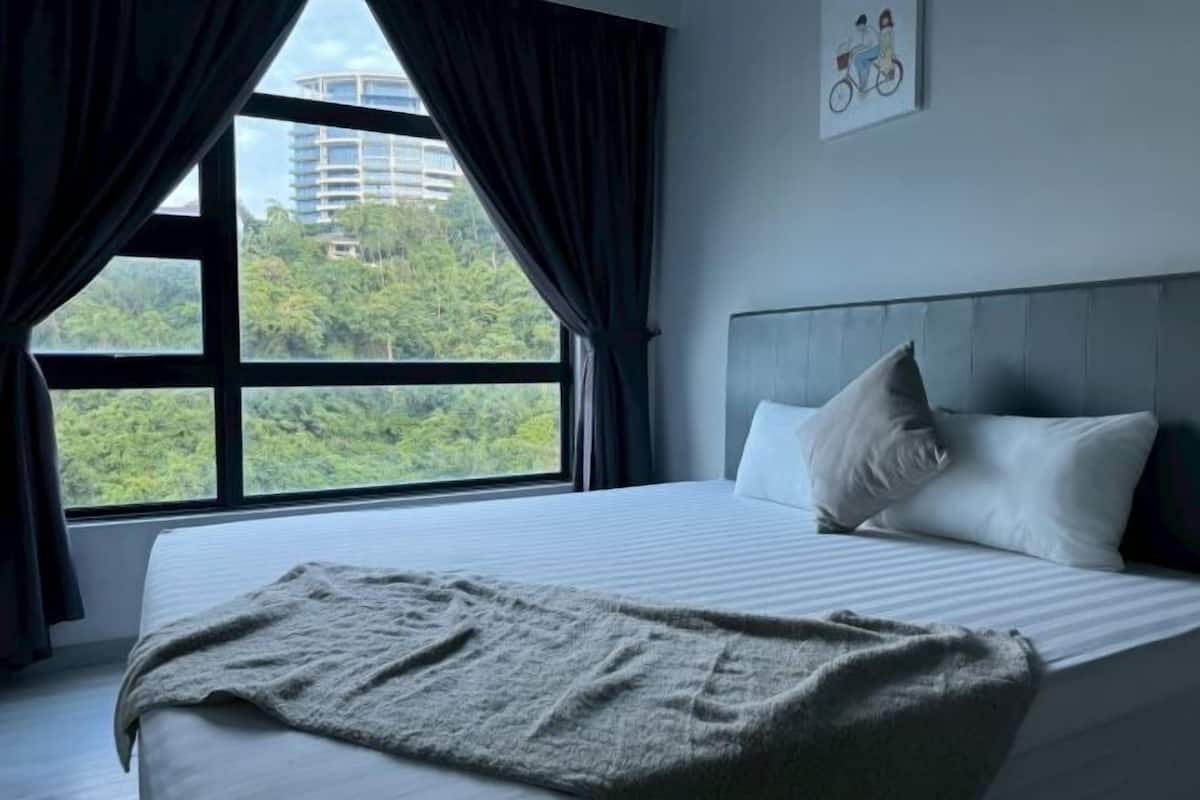 Ein Hotelzimmer mit großem Fenster, einem Bett mit weißer Bettwäsche und einer grauen Decke.