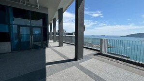 Un balcon avec vue sur la mer et une île lointaine.