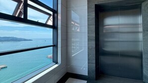 Un ascenseur moderne offrant une vue sur la mer grâce à une grande fenêtre.