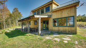 A wooden cabin with a covered patio and a large window. - Unplug, Unwind & Explore: Remote Vermont Cabin (Sharon)