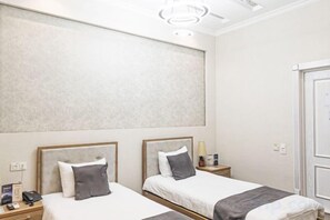 A hotel room with two beds, a large mirror, and a door. - Merhaba Hotel (Fergana)