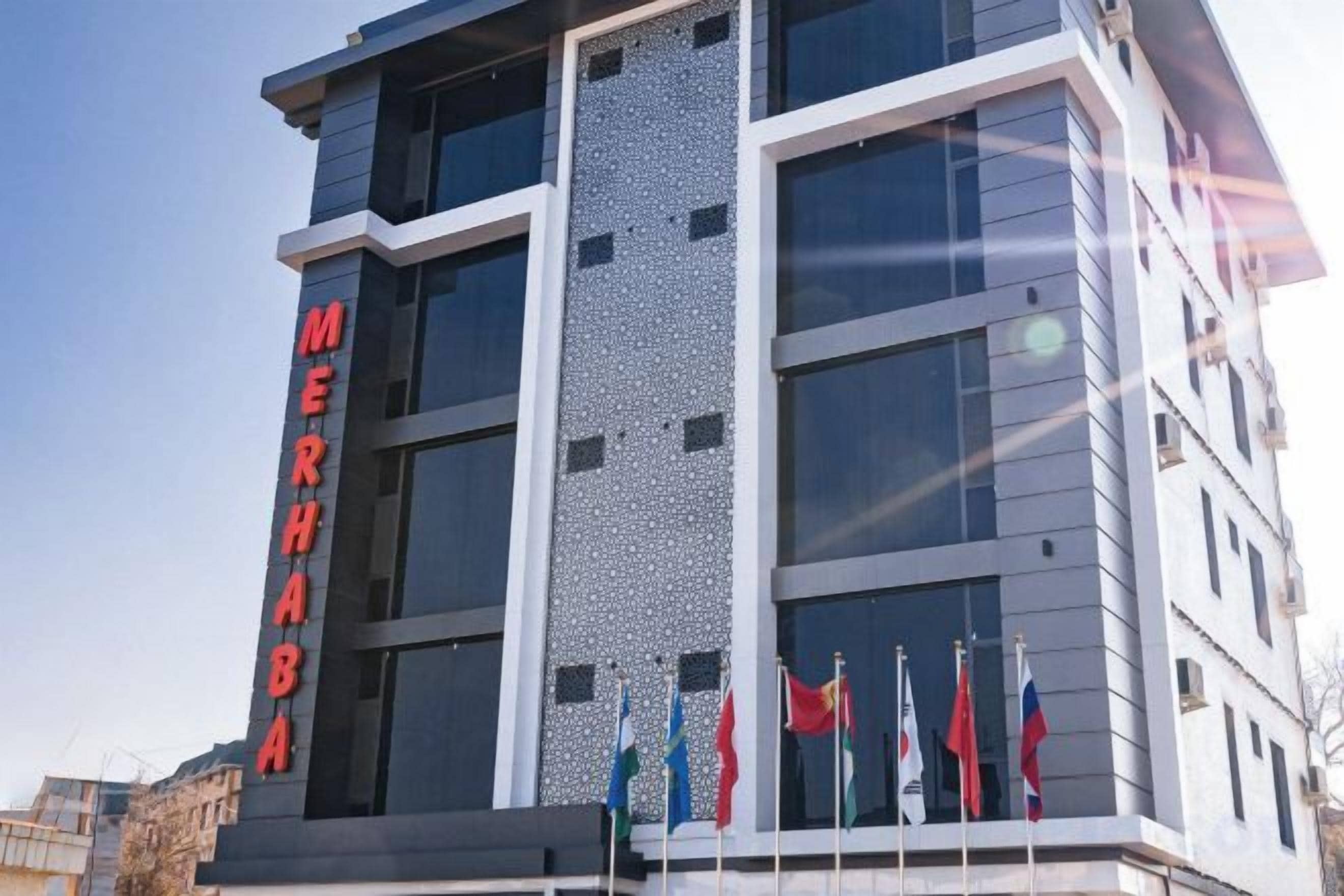 A hotel building with a prominent sign reading 'MERHABA' and multiple flags at the entrance.