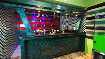 A bar area with a checkered wall pattern, a marble counter, and a green accent wall.