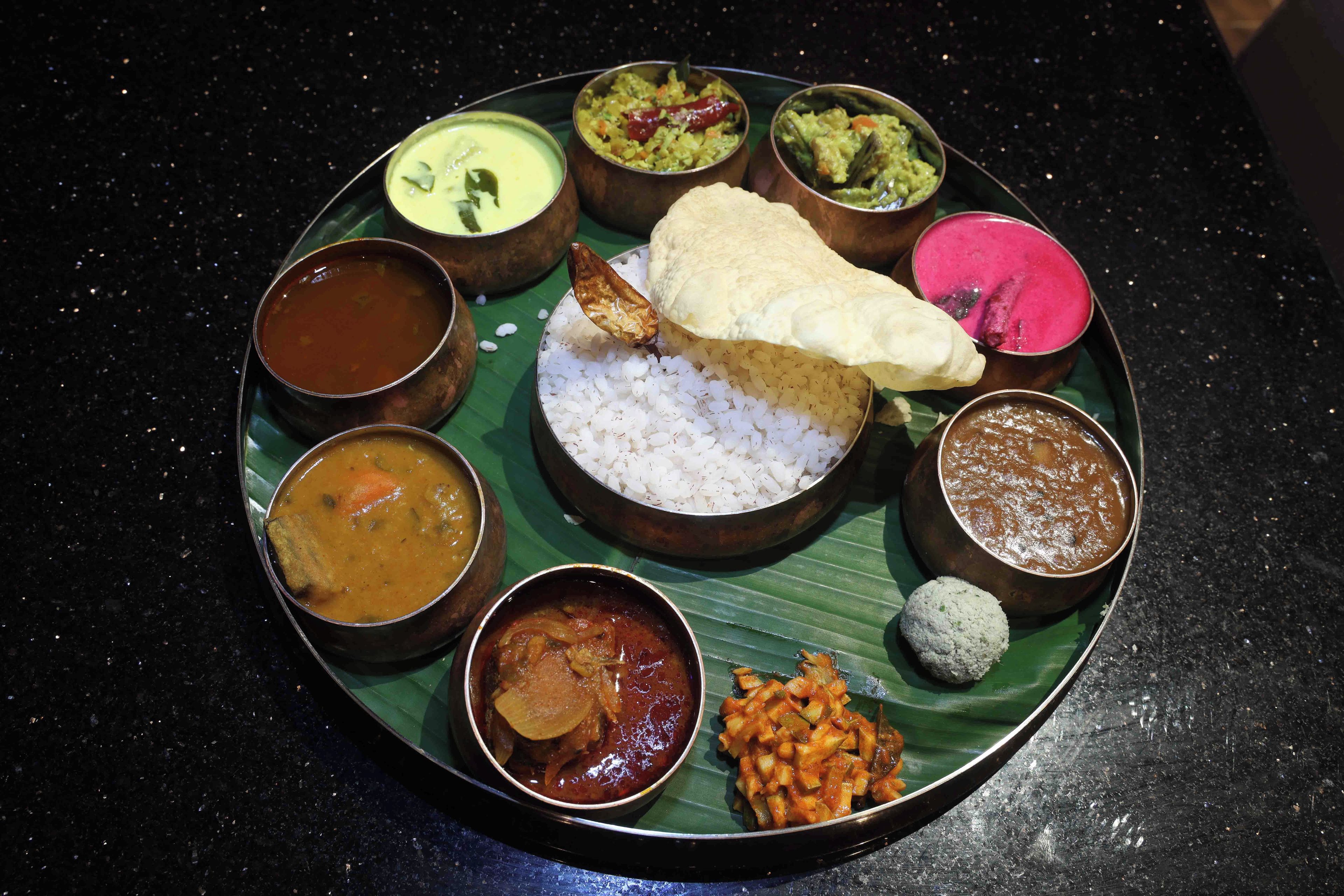 Una comida tradicional del sur de la India con arroz, diferentes guisos y una flor de plátano.