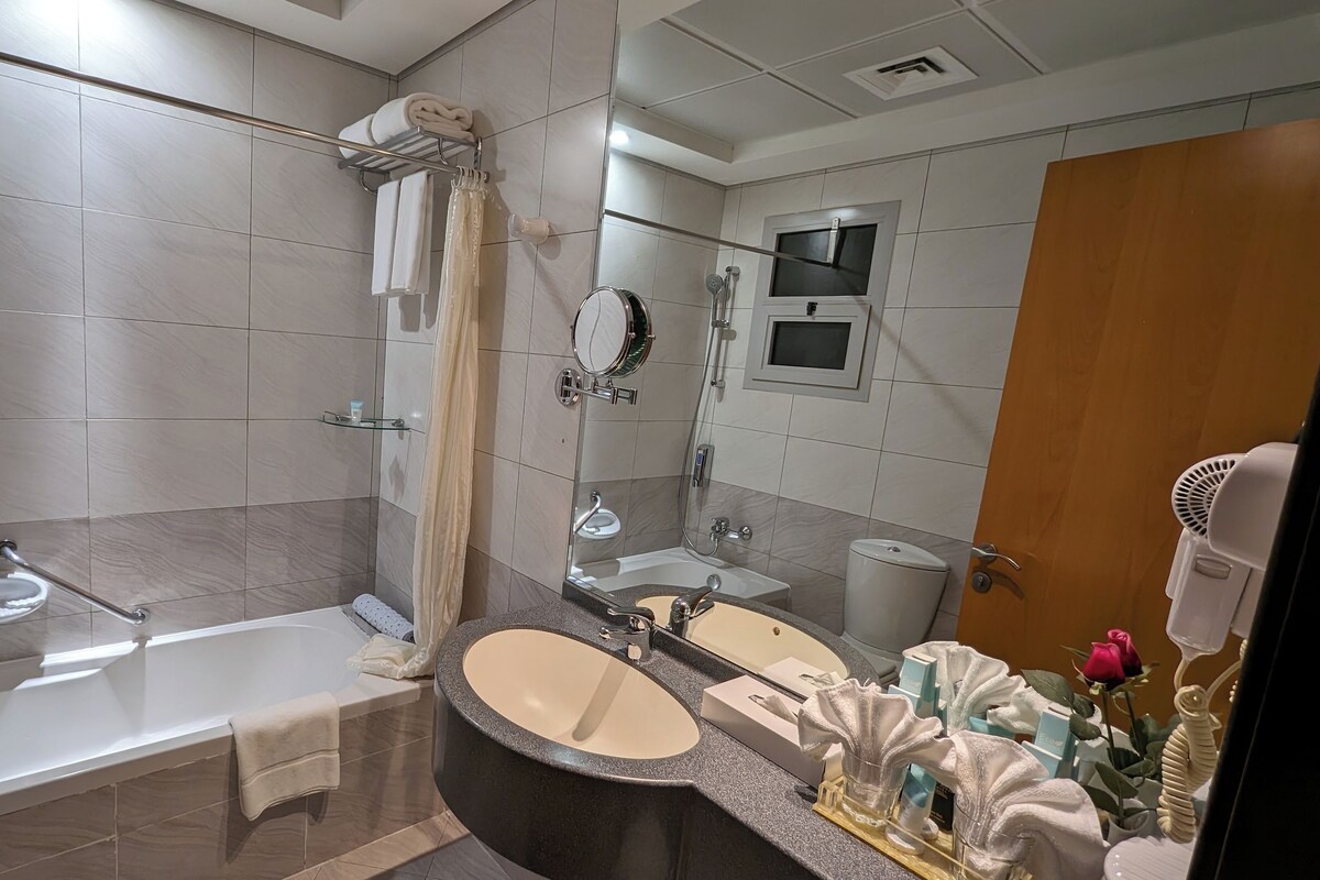 Un bagno moderno con vasca, un ampio specchio, un mobile lavabo e un box doccia.