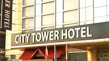 Exterior del Hotel City Tower con una camioneta SUV blanca estacionada frente al hotel.