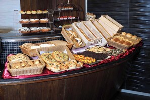 Un buffet proposant une variété de produits de boulangerie et de pâtisserie.
