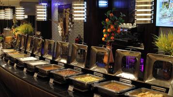 Een buffetgedeelte met verschillende foodstations, elk met een afgedekte serveerplank.