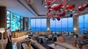 Un hall d’entrée spacieux avec un bar, des sièges confortables et une grande fenêtre donnant sur la mer.