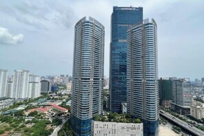 Two high-rise buildings with a clear sky and surrounding urban landscape.