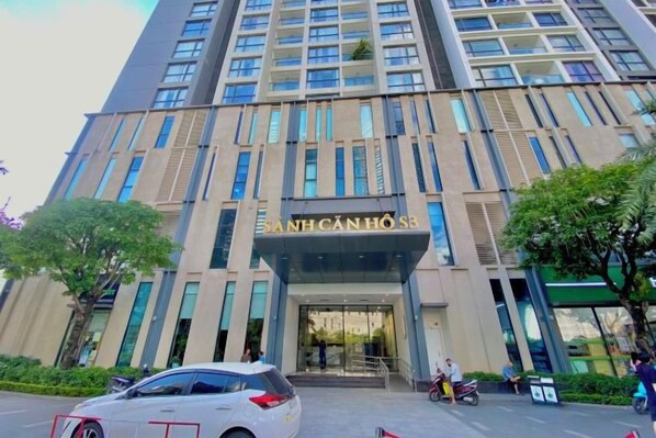 Un hotel de varios pisos con una entrada destacada y un letrero sobre las puertas.