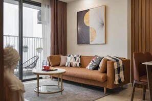 Una sala de estar moderna con un sofá, una mesa de centro y un sillón. Hay un balcón con barandilla y plantas en macetas.