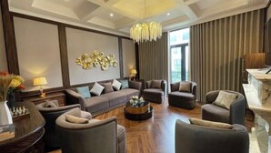 Ein modernes Wohnzimmer mit einer Sofagarnitur, Sesseln, einem Couchtisch und einer Chandelier.