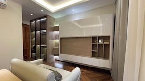 Ein modernes Zimmer mit einer Couch, integrierten Regalen und einer Deckenleuchte.