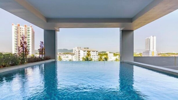 Piscina infinita no terraço com vista desobstruída dos edifícios ao redor.