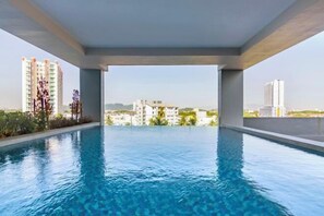 A rooftop infinity pool with a clear view of surrounding buildings. - Marc CoLiving by Cobytat (Bukit Mertajam)