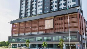Um edifício moderno de vários andares com um letreiro 'RC' bem visível, indicando um espaço comercial.