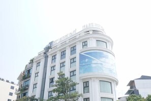 A multi-story hotel with a curved facade, large windows, and a prominent corner design.