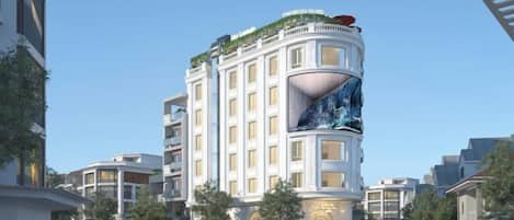 A modern hotel with a curved facade, multiple balconies, and a prominent water feature.