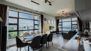 A modern kitchen with a dining area, large windows, and a city view. - Jesselton Quay Seaview Suite by HayBay (Kota Kinabalu)