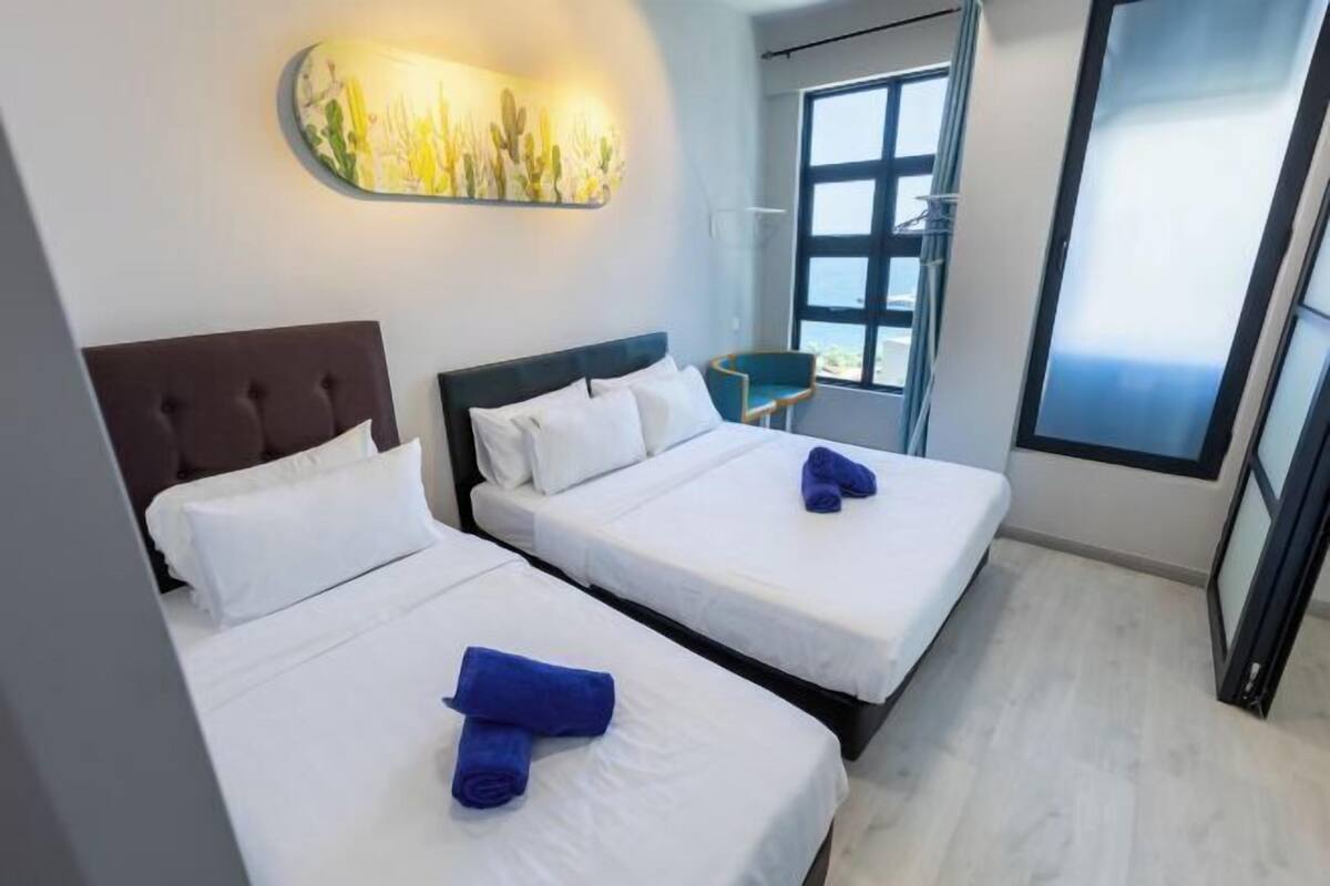 A hotel room with two beds, a large window, and a modern wall art piece.