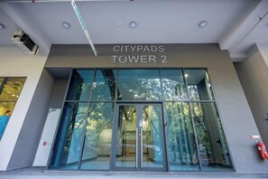 CITYPADS TOWER 2 entrance with glass doors and a fire extinguisher on the right.