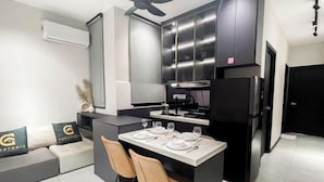 Une cuisine moderne avec un coin repas, des placards intégrés et un ventilateur de plafond.