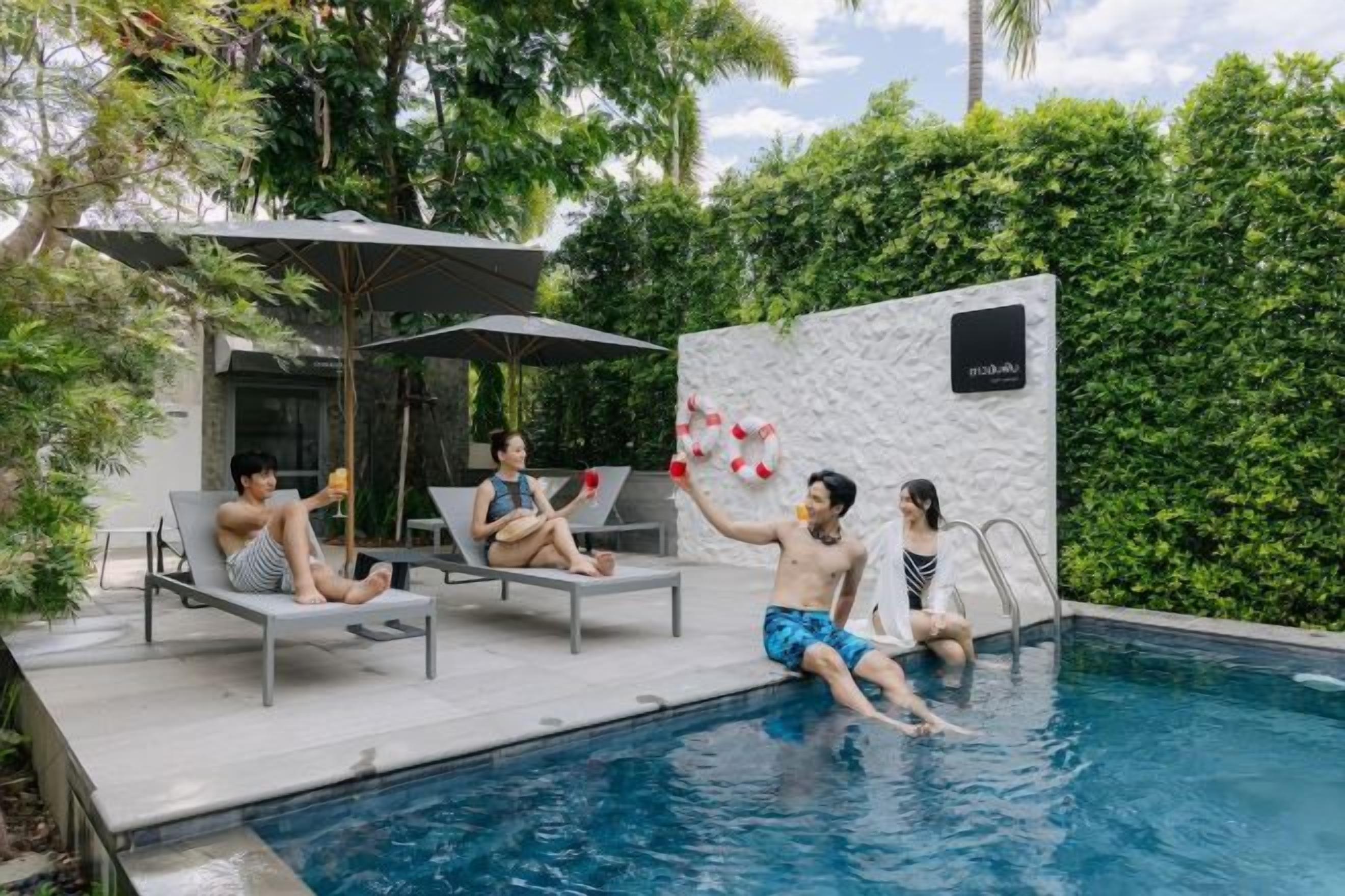 A pool area with lounge chairs and a wall-mounted sign.