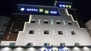 A hotel with a modern facade, illuminated signage, and multiple windows. - sweetdream (Jinju)