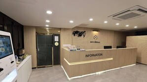 A reception desk with a sign reading "INFORMATION" and a wall-mounted logo. - sweetdream (Jinju)