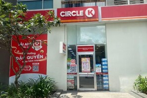 A Circle K convenience store with a clear entrance, a visible signboard, and a QR code for digital interaction. - VINHOMES CENTRAL PARK LUXURY APARTMENT (Ho Chi Minh City)