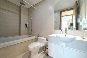 Une salle de bain moderne avec une baignoire, des toilettes et un meuble-lavabo.